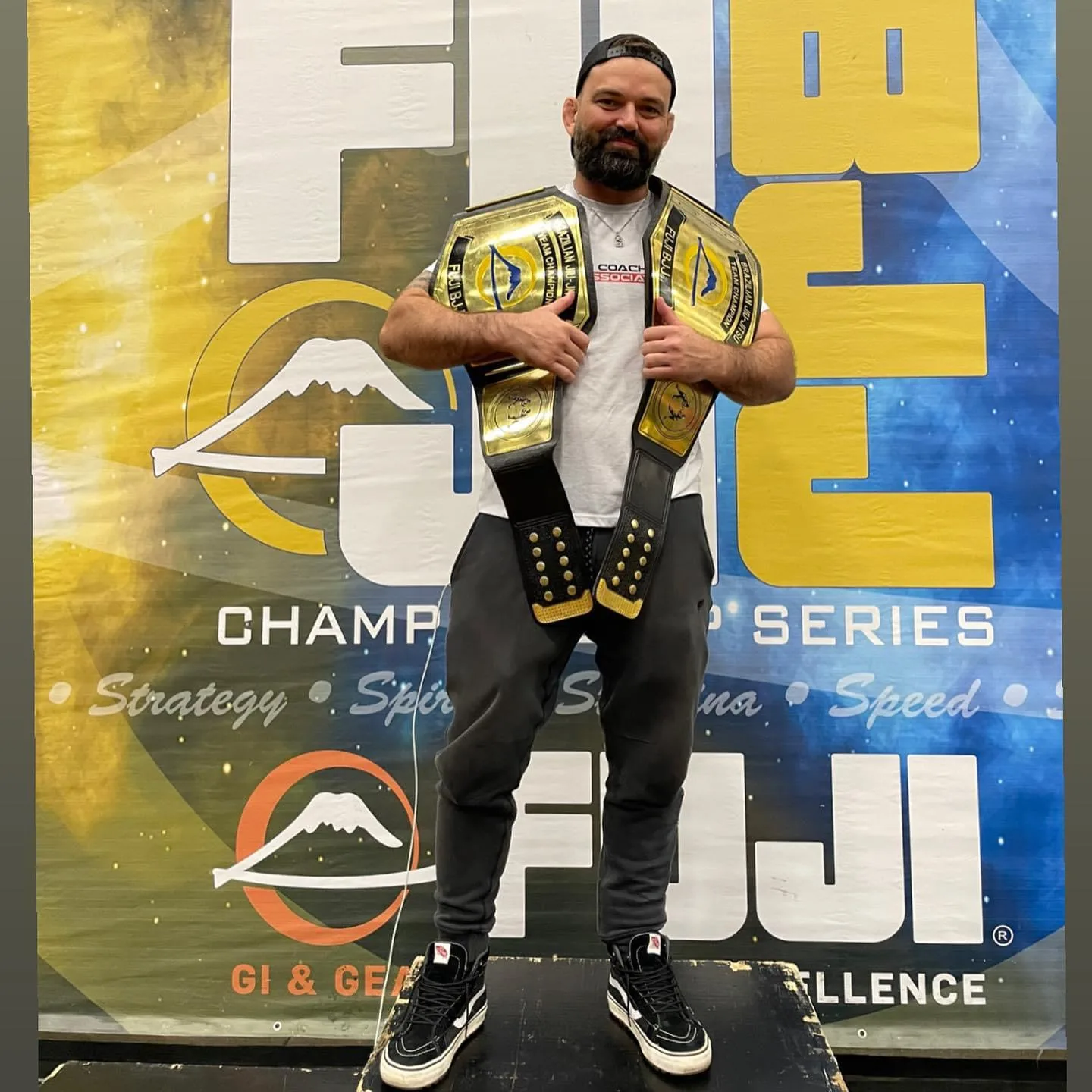 Coach Jon Correa with a championship belt